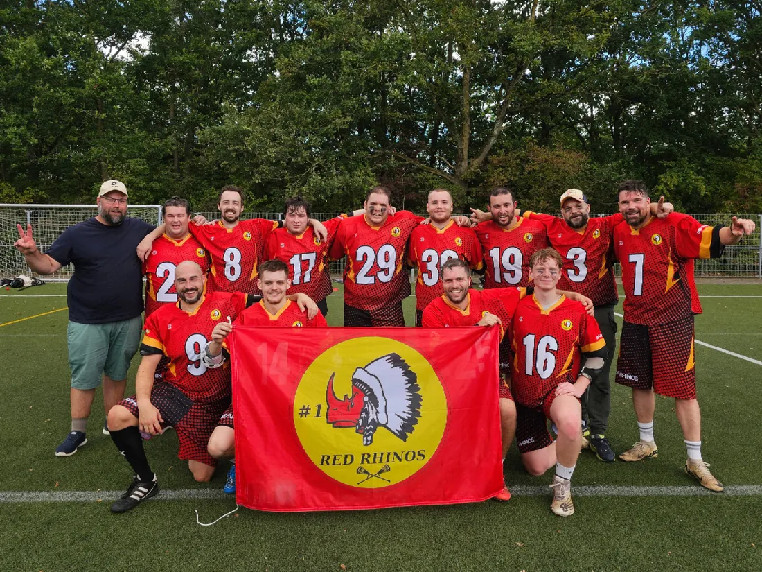 Het mannenteam van Red Rhinos met de clubvlag